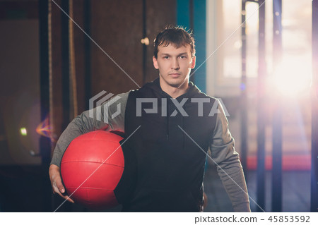 Athletic man doing abdomen exercise on the floor. Man doing workout using a medicine ball at the gym Athletic man doing abdomen exercise on the floor. Man doing workout using a medicine ball at the gym 45853592