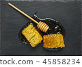 honeycomb and honey stick on a black 45858234