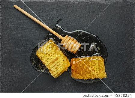 honeycomb and honey stick on a black honeycomb and honey stick on a black 45858234