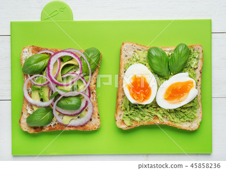 Two avocado toasts on green background Two avocado toasts on green background 45858236