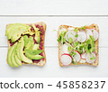 Two avocado toasts on white wooden background 45858237