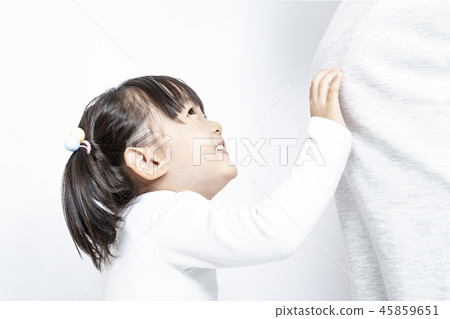 A little girl who touches her mother's big belly during late pregnancy. Family, parenting, pregnancy, love, happiness image 45859651