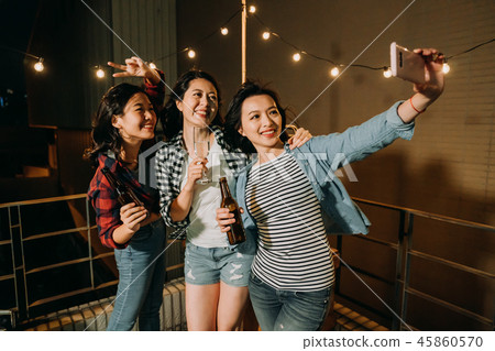 asian girls taking self portrait on rooftop party 45860570