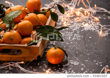 Image of tangerines in wooden box with burning garland 45861887