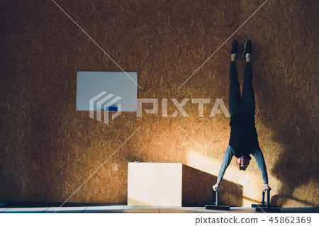 Young man lifting dumbbell and kettlebell at the fitness center. head down 45862369