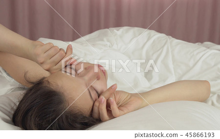 Beautiful teen girl wakes up in bed and smiles Beautiful teen girl wakes up in bed and smiles 45866193