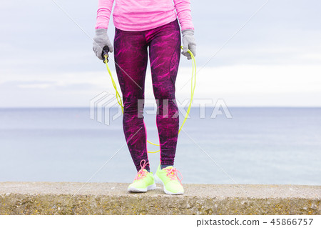 Woman training outdoor with jump rope on cold day Woman training outdoor with jump rope on cold day 45866757