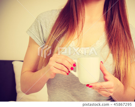 Woman holding cup of hot drink, no face Woman holding cup of hot drink, no face 45867295