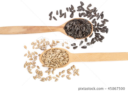 peeled and unpeeled seeds in a wooden spoon isolated on white background. Top view peeled and unpeeled seeds in a wooden spoon isolated on white background. Top view 45867500