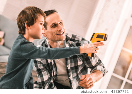Loving responsible father and imaginative son playing spies with a glue gun. Loving responsible father and imaginative son playing spies with a glue gun. 45867751