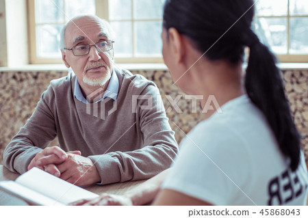 Serious mature man looking at his social worker 45868043