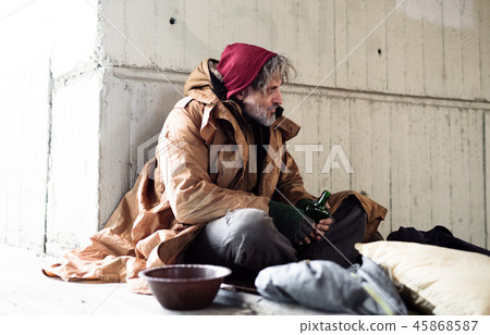 Homeless beggar man sitting outdoors in city asking for money donation. Homeless beggar man sitting outdoors in city asking for money donation. 45868587