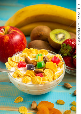Tasty cornflakes with milk and fruits in glass bowl Tasty cornflakes with milk and fruits in glass bowl 45869123