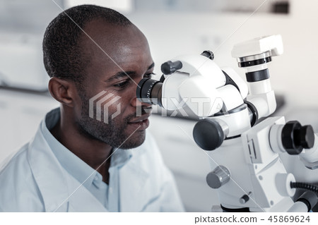 Professional medical worker staring at ocular of microscope 45869624