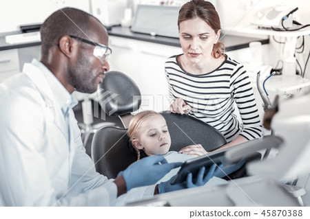 Concentrated female person sitting near her daughter 45870388