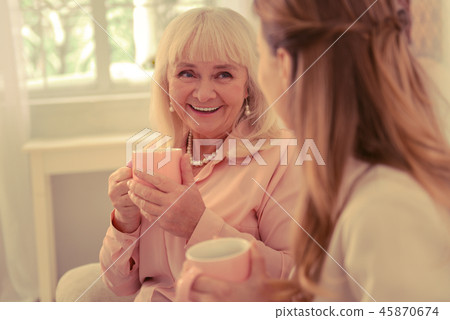 Delighted nice elderly woman visiting her daughter Delighted nice elderly woman visiting her daughter 45870674