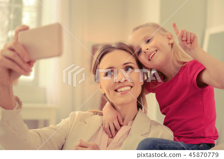 Happy positive mom and daughter taking selfies together 45870779