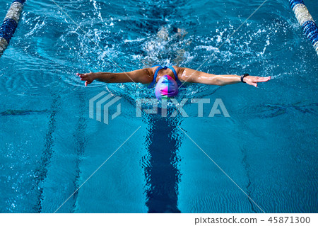 Female athlete swims with a butterfly style. Female athlete swims with a butterfly style. 45871300