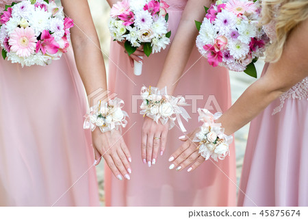 Bridesmaids in pink dresses holding flowers Bridesmaids in pink dresses holding flowers 45875674
