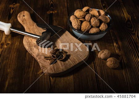 Walnuts in an old bowl with a kitchen ax 45881704