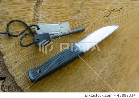 Fix knife with firestone on wood background. Oak w Fix knife with firestone on wood background. Oak w 45882334