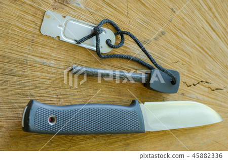 Tourist knife with flint. Knife and flint on wood Tourist knife with flint. Knife and flint on wood 45882336