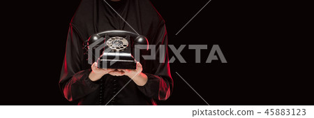 Portrait of beautiful serious scared young muslim woman wearing black hijab offering telephone to Portrait of beautiful serious scared young muslim woman wearing black hijab offering telephone to 45883123
