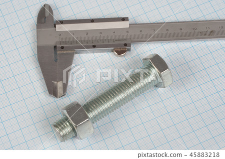 Screw, Nuts and caliper on graph paper background 45883218