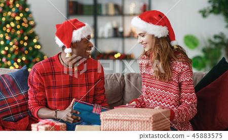 happy couple opening presents on Christmas morning happy couple opening presents on Christmas morning 45883575