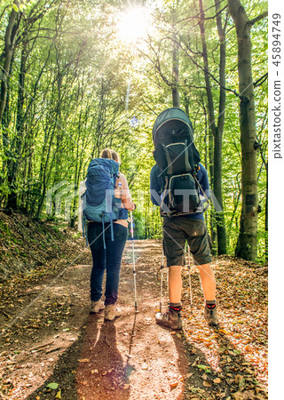 Man Woman family baby backpack Hiking in the forest on a sunny day in nature 45894749