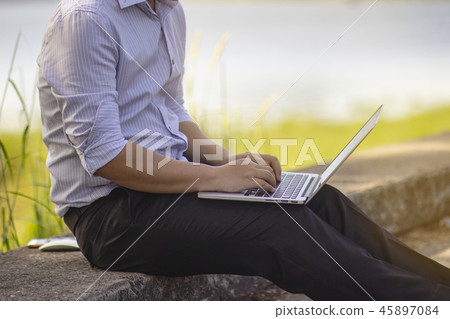 The man sitting nere a reservoir.He is working. The man sitting nere a reservoir.He is working. 45897084