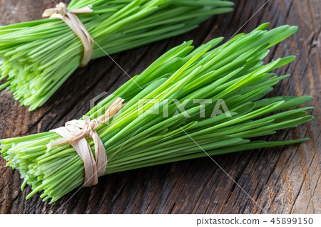 Fresh barley grass blades on a rustic background 45899150