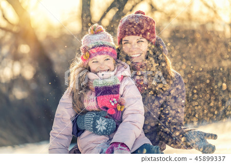 Mother and daughter playing in winter park 45899337