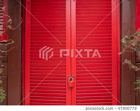 closed red wooden window shutters with small lock 45900779