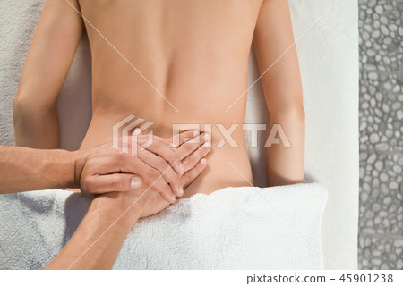 View from above of hands of masseur doing back massage 45901238