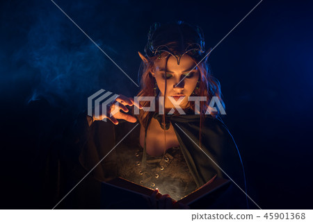 Red haired elf in silver tiara learning spells from book. Red haired elf in silver tiara learning spells from book. 45901368