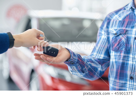 Crop of hands when one person giving car's key to another.  45901373