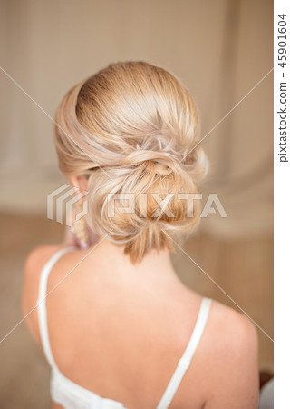 Rear view of female hairstyle middle bun with blond hair 45901604