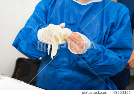 Nurse putting on surgical gloves 45903395