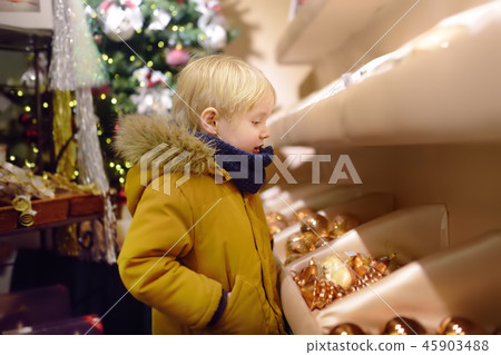 Little boy chooses Christmas decorations in store. Little boy chooses Christmas decorations in store. 45903488