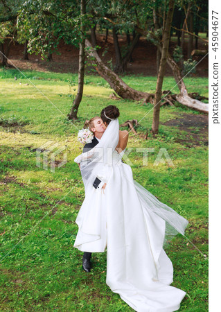 Happy bride and groom after wedding ceremony hugging and kissing Happy bride and groom after wedding ceremony hugging and kissing 45904677