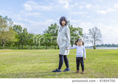 懷孕飢餓的大母親和小女孩在公園裡玩。家庭，父母和孩子，愛，幸福的形象 45904700