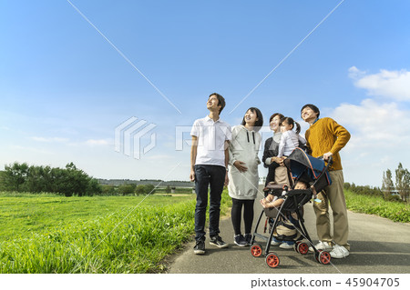 A pregnant couple looking up into the distance with a friend who already has two children 45904705