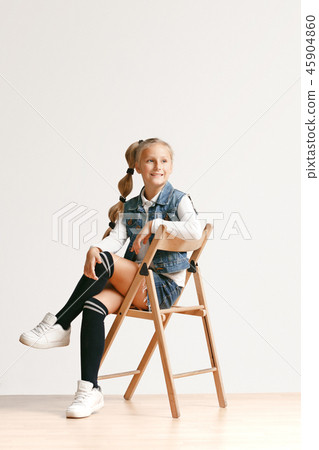Full length portrait of cute little teen in stylish jeans clothes looking at camera and smiling 45904860