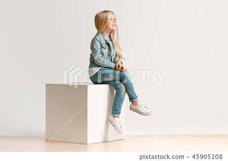 The portrait of cute little kid in stylish jeans clothes looking at camera and smiling The portrait of cute little kid in stylish jeans clothes looking at camera and smiling 45905108