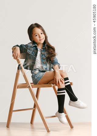 Full length portrait of cute little kid in stylish jeans clothes looking at camera and smiling 45905180