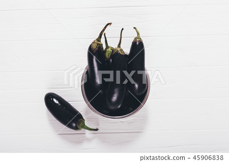 Raw purple eggplants on white wooden table Raw purple eggplants on white wooden table 45906838