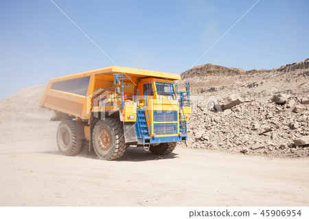 Yellow dump truck moving in a mine 45906954