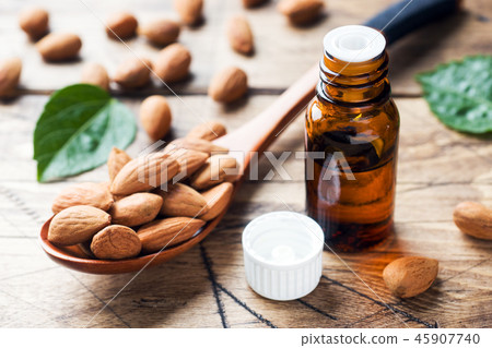 Almond oil in bottle on wooden background. Almond oil in bottle on wooden background. 45907740