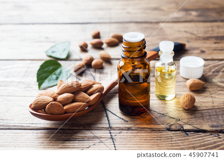 Almond oil in bottle on wooden background. Almond oil in bottle on wooden background. 45907741
